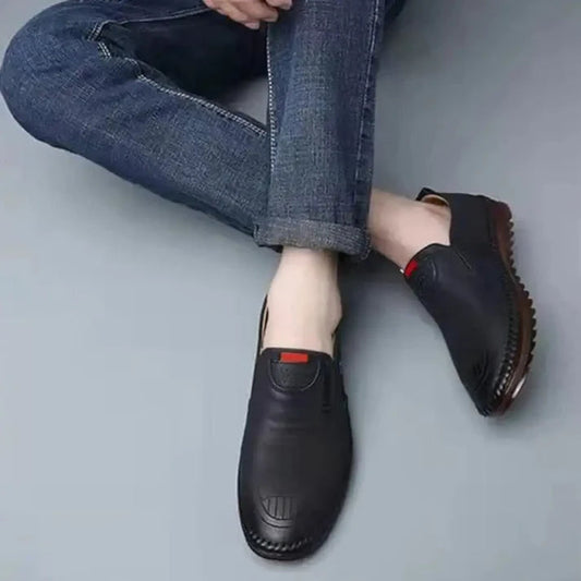 Men wearing men's black casual shoes with slip-on design and textured soles paired with blue jeans