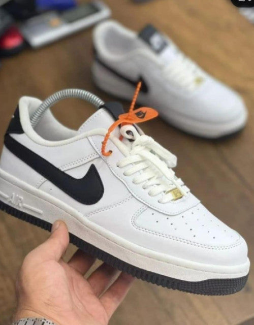 White and black Nike men's casual sneakers online with orange tag and cushioned sole