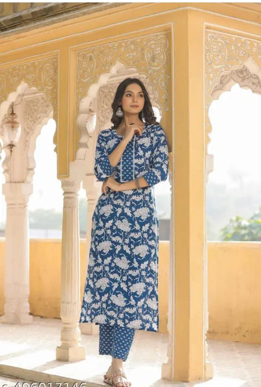Woman wearing premium quality kurti for women in blue floral design with matching pants in traditional setting