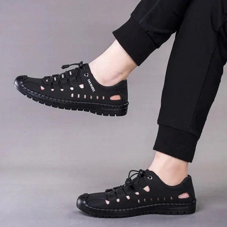 Black men's casual fashion shoes with breathable cutouts and flexible sole worn with black pants