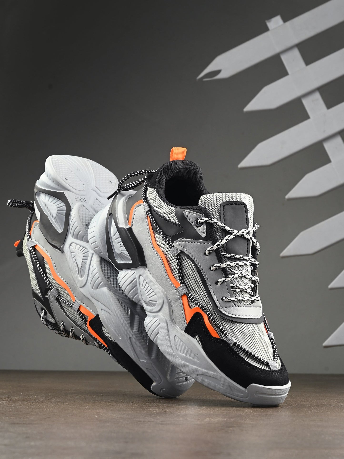 Grey sports shoes for men with black and orange accents and cushioned soles for comfort
