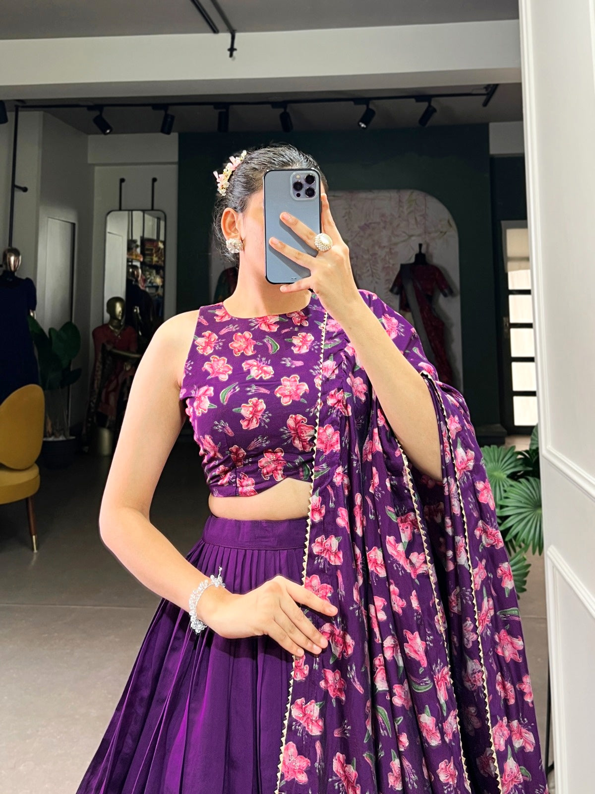 Woman wearing a premium quality designer lehenga in purple with floral patterns and matching dupatta