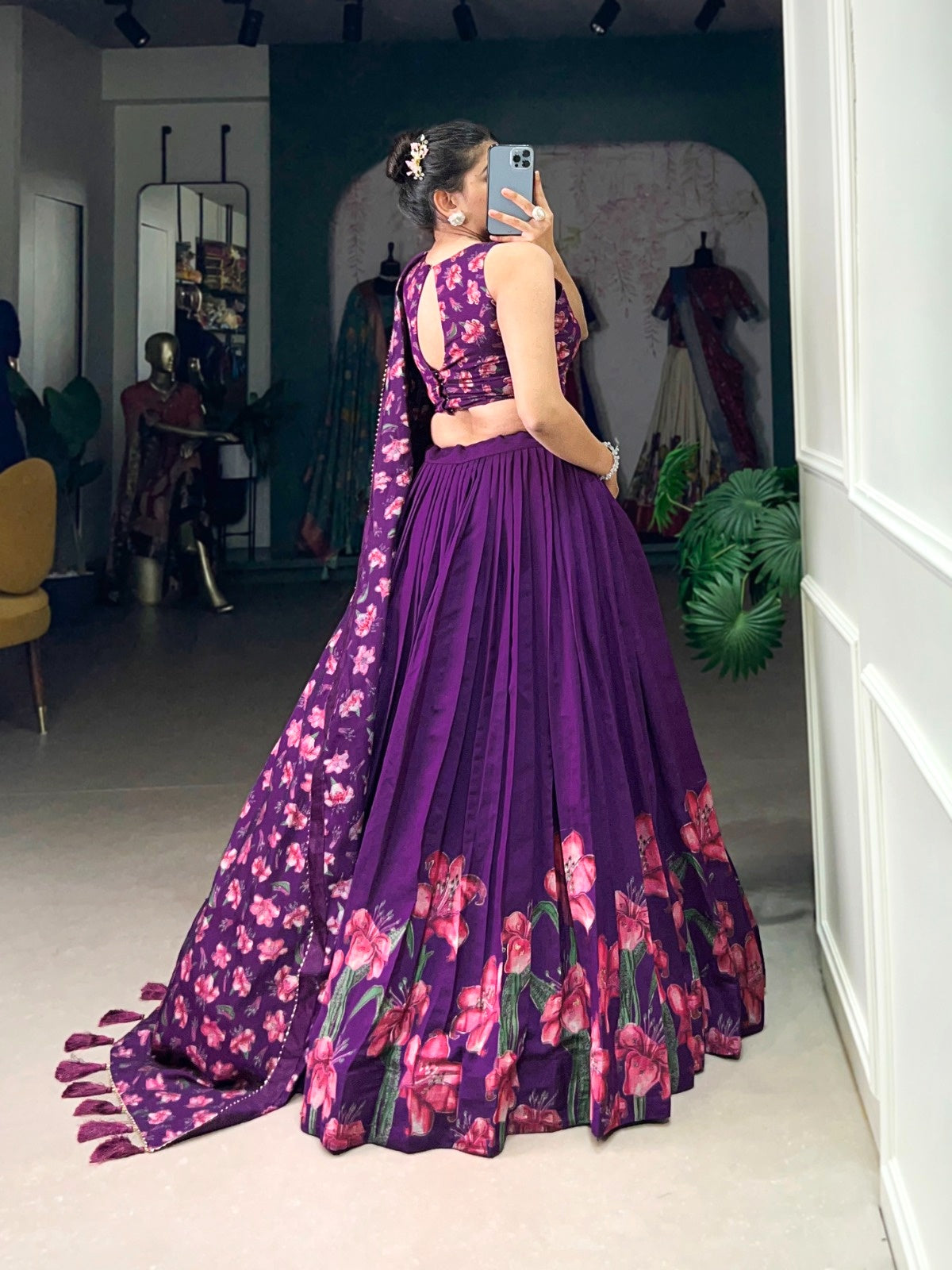 Woman wearing premium quality designer lehenga in purple with floral patterns and sleeveless choli