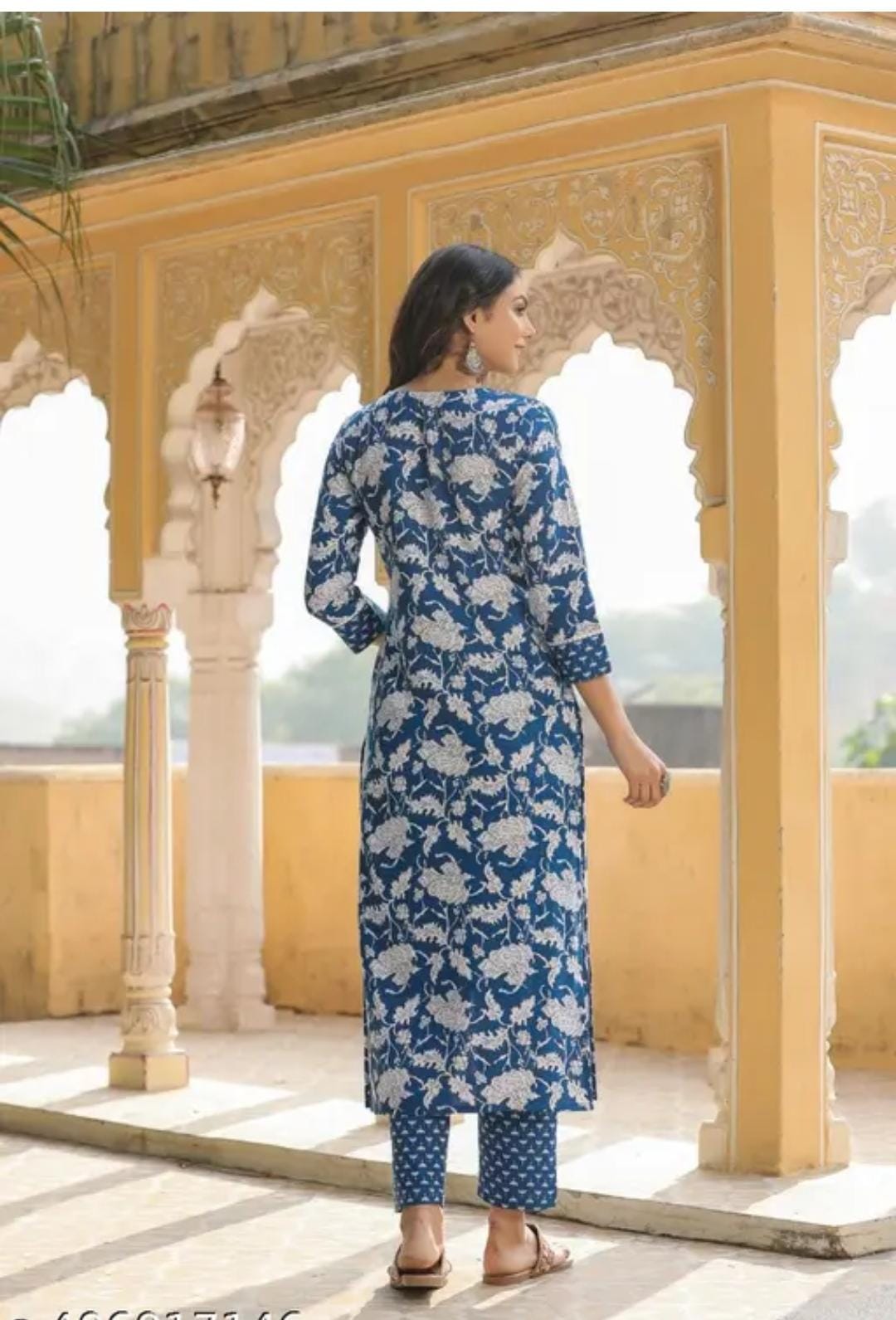 Woman wearing a premium quality kurti for women in blue floral print with matching pants in traditional setting