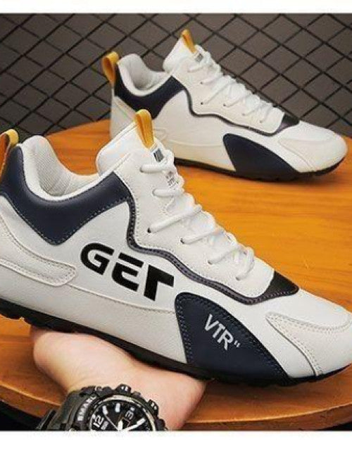 White and black men's dailywear sports shoes with lace-up design displayed on a wooden table