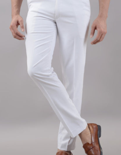 White formal trousers for men styled with brown leather shoes in a minimalist setting